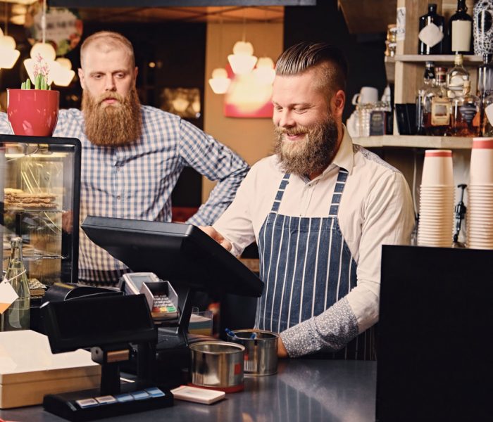 a-man-at-the-counter-using-cash-register-in-a-coff-2V4Y292